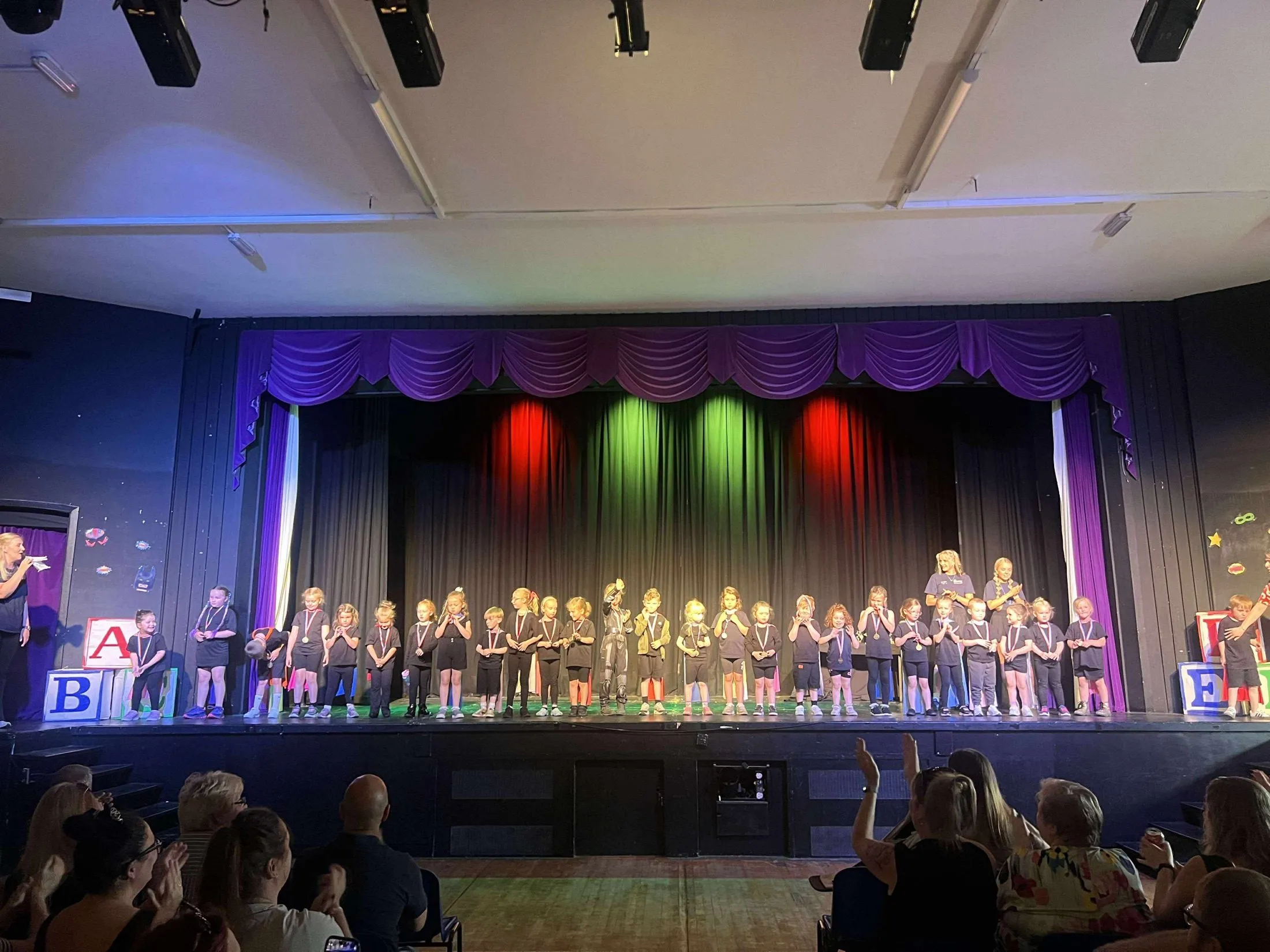 Young STAMP performers together on stage during a Minis session